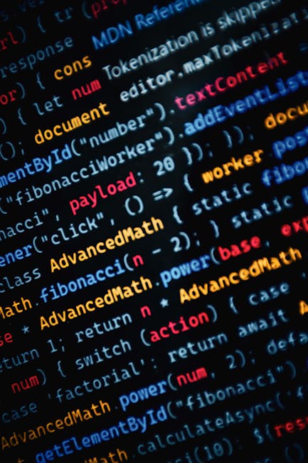 Close-up view of a MacBook Pro laptop displaying a coding editor with HTML code for a web page. The screen shows a section of code in a text editor, highlighting elements such as <section>, <div>, <h1